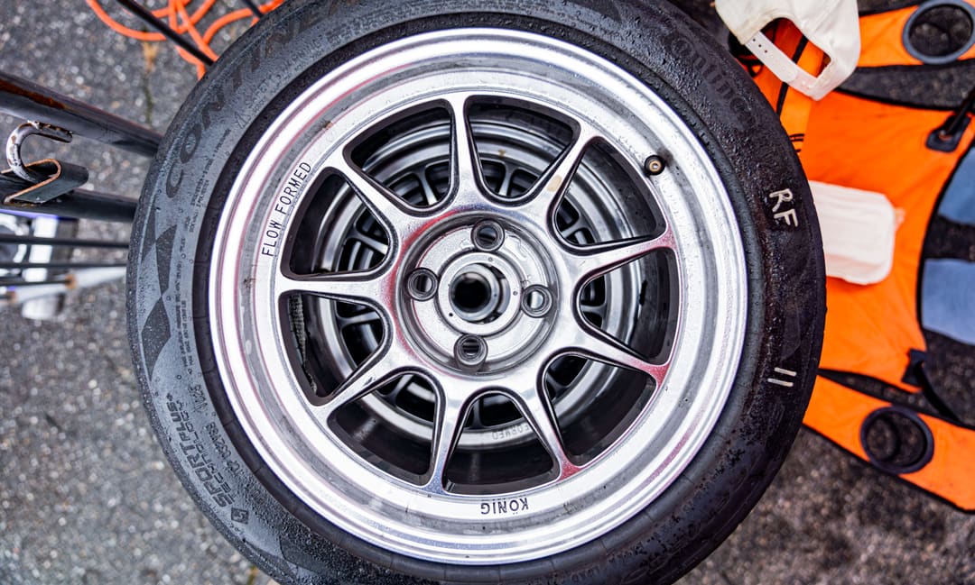 A scrubbed slick on a lightweight wheel, pulled off between stints.