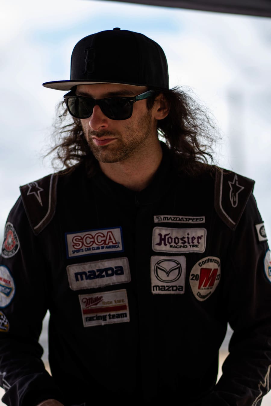 The crew chief in the paddock, cap and sunglasses.
