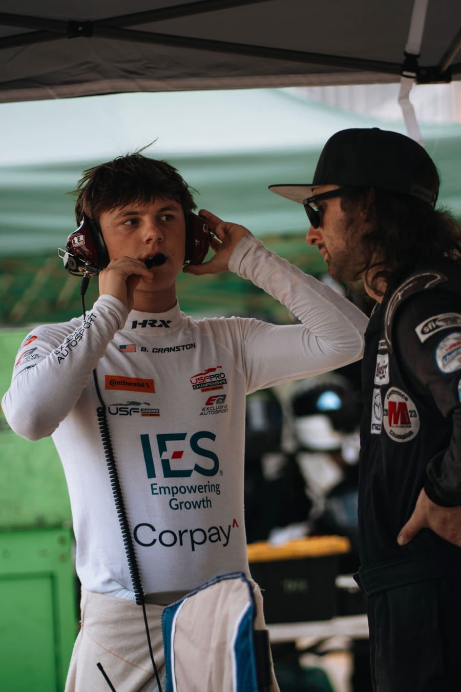 Driver and crew chief on the radio under the awning.