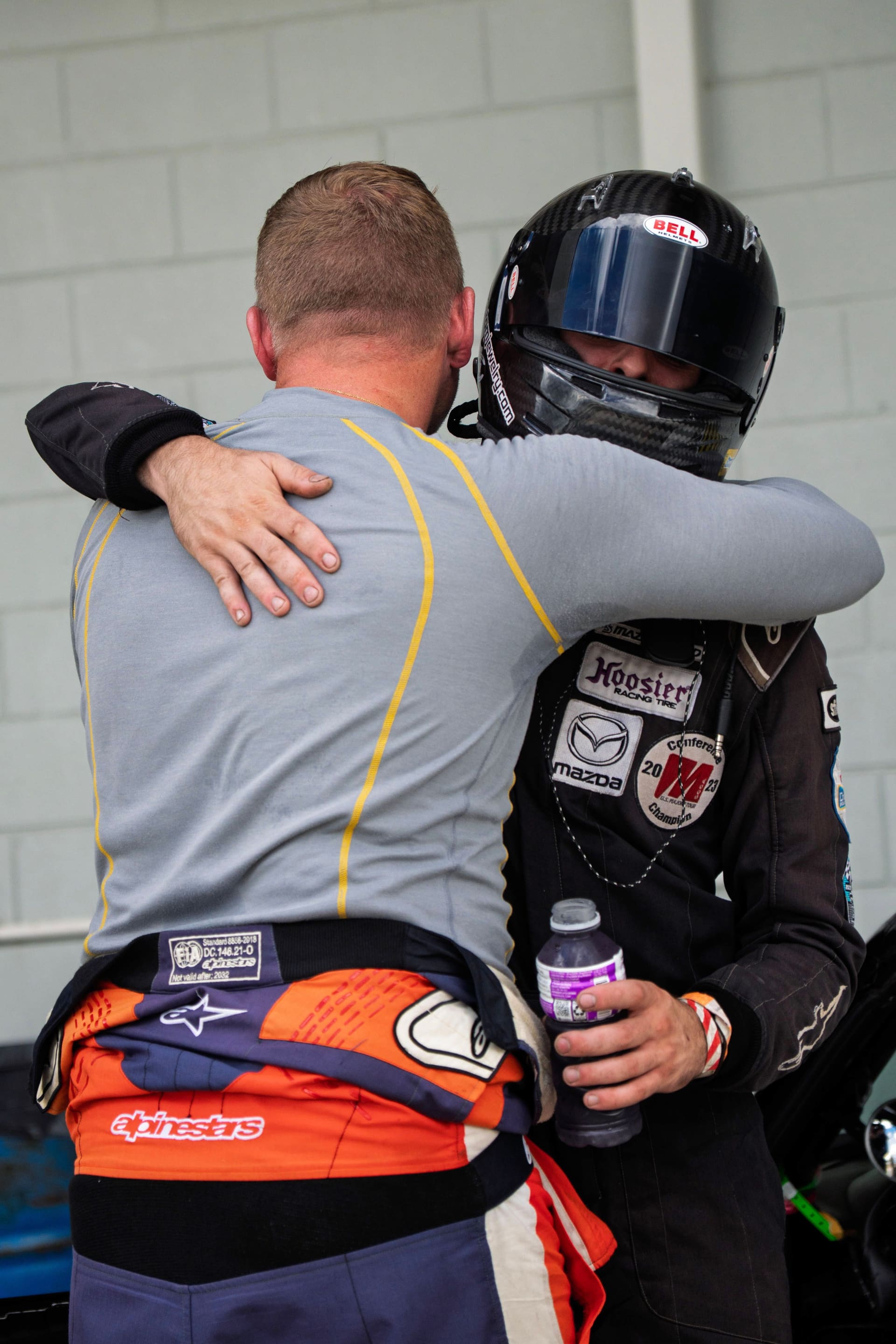 Two drivers embracing in the garage after the finish.
