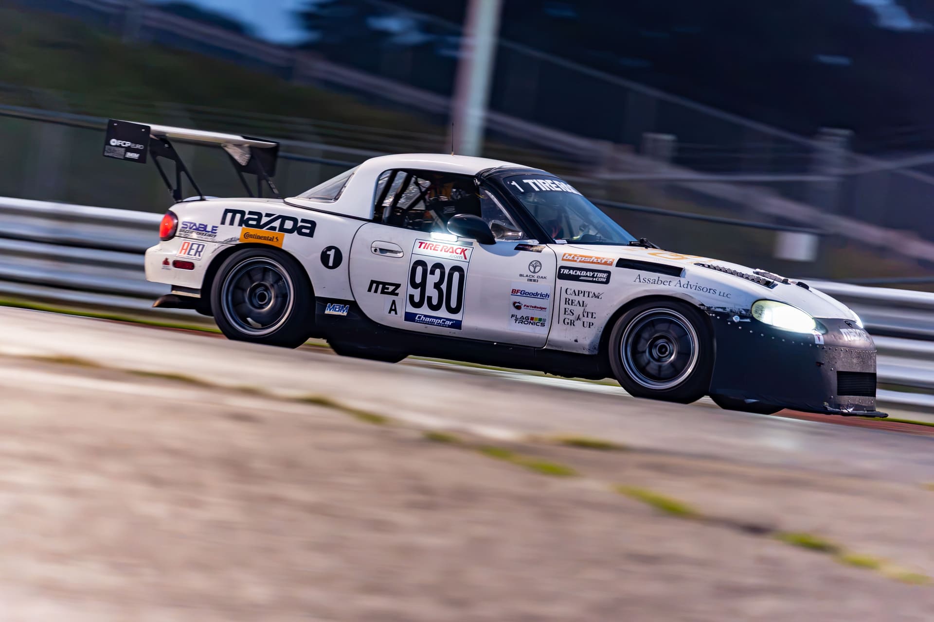 Panning shot of the #930 at speed, livery lit by trackside light.