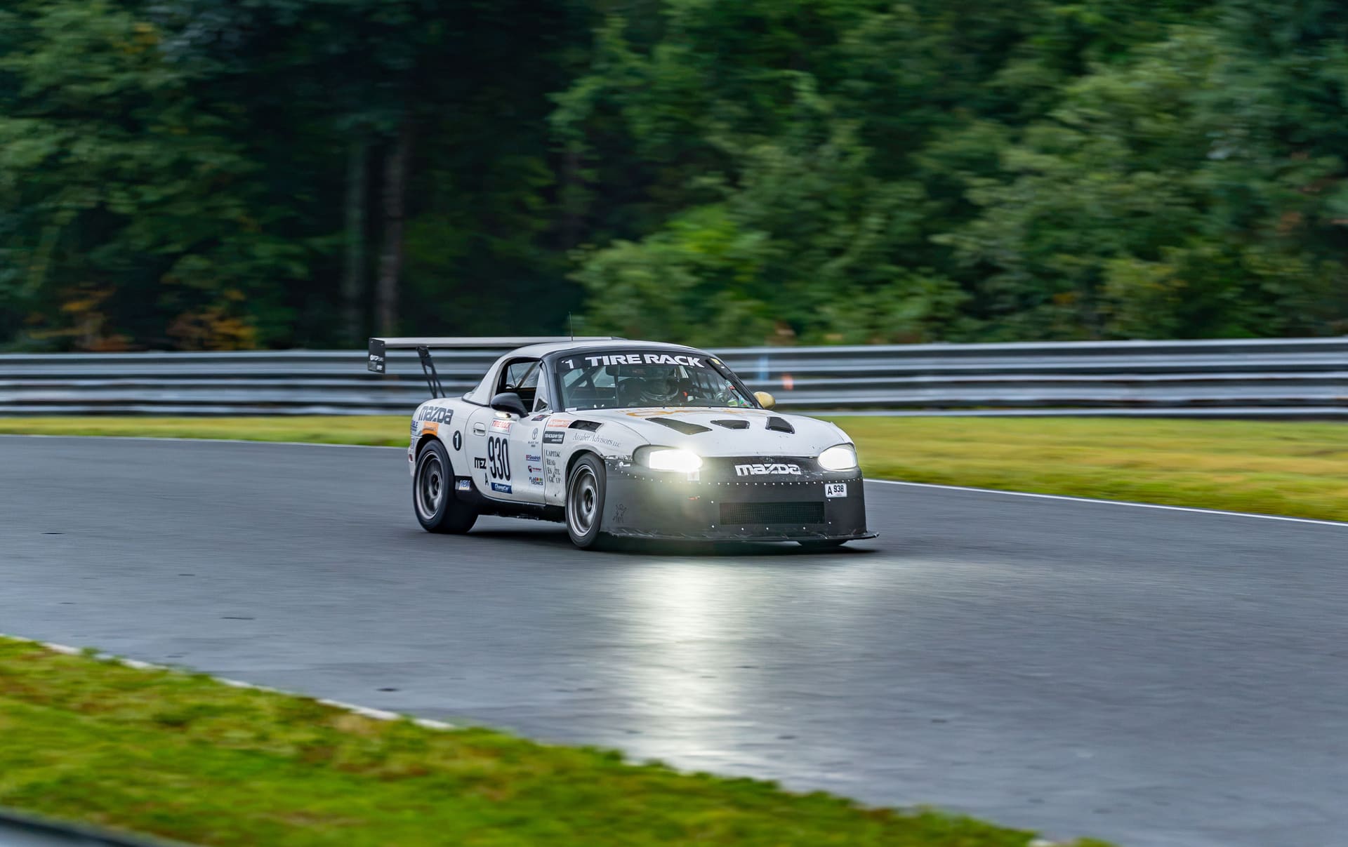 The car running into the dark on a damp circuit.