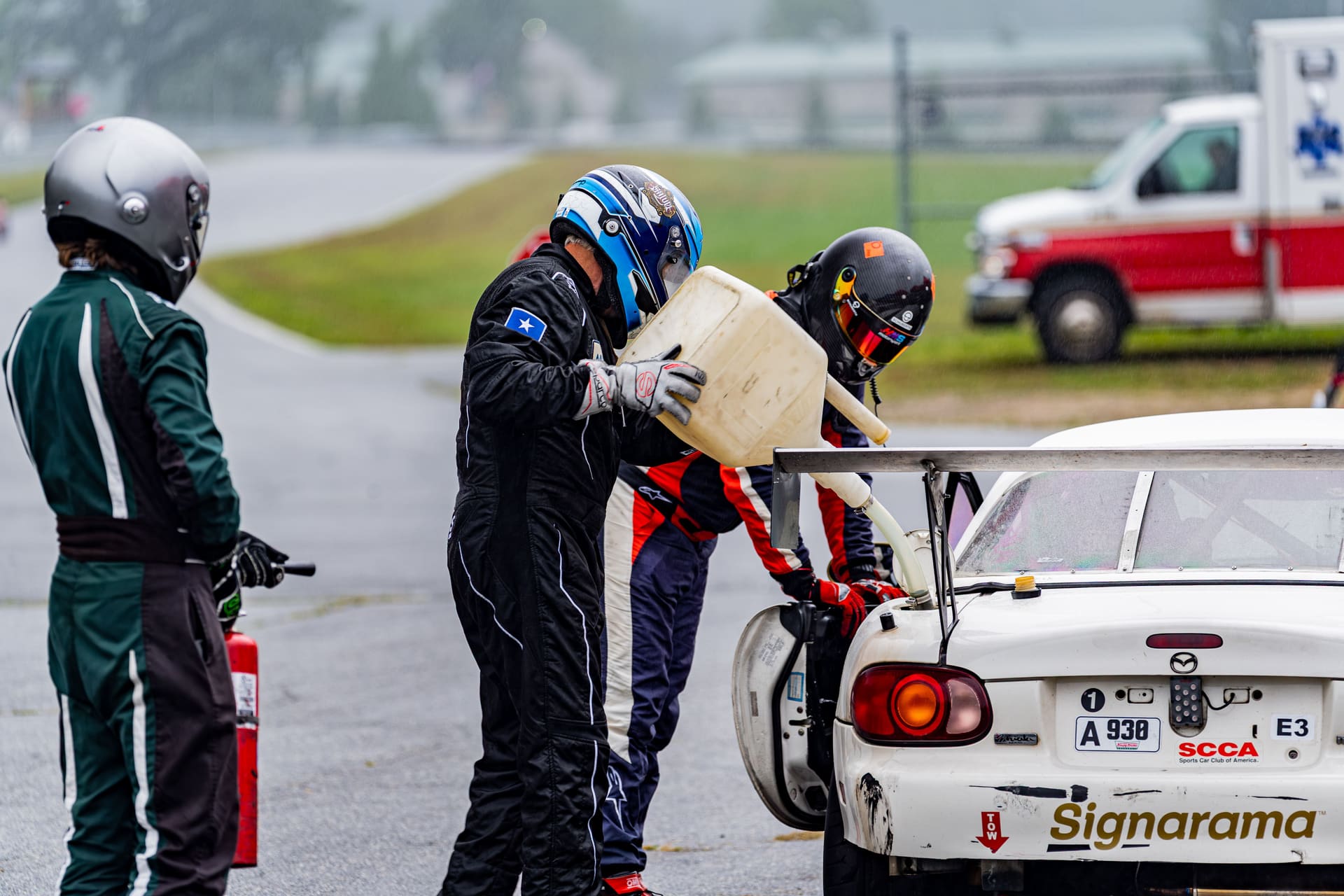 Refuelling over the wall in the rain, fire bottle ready.