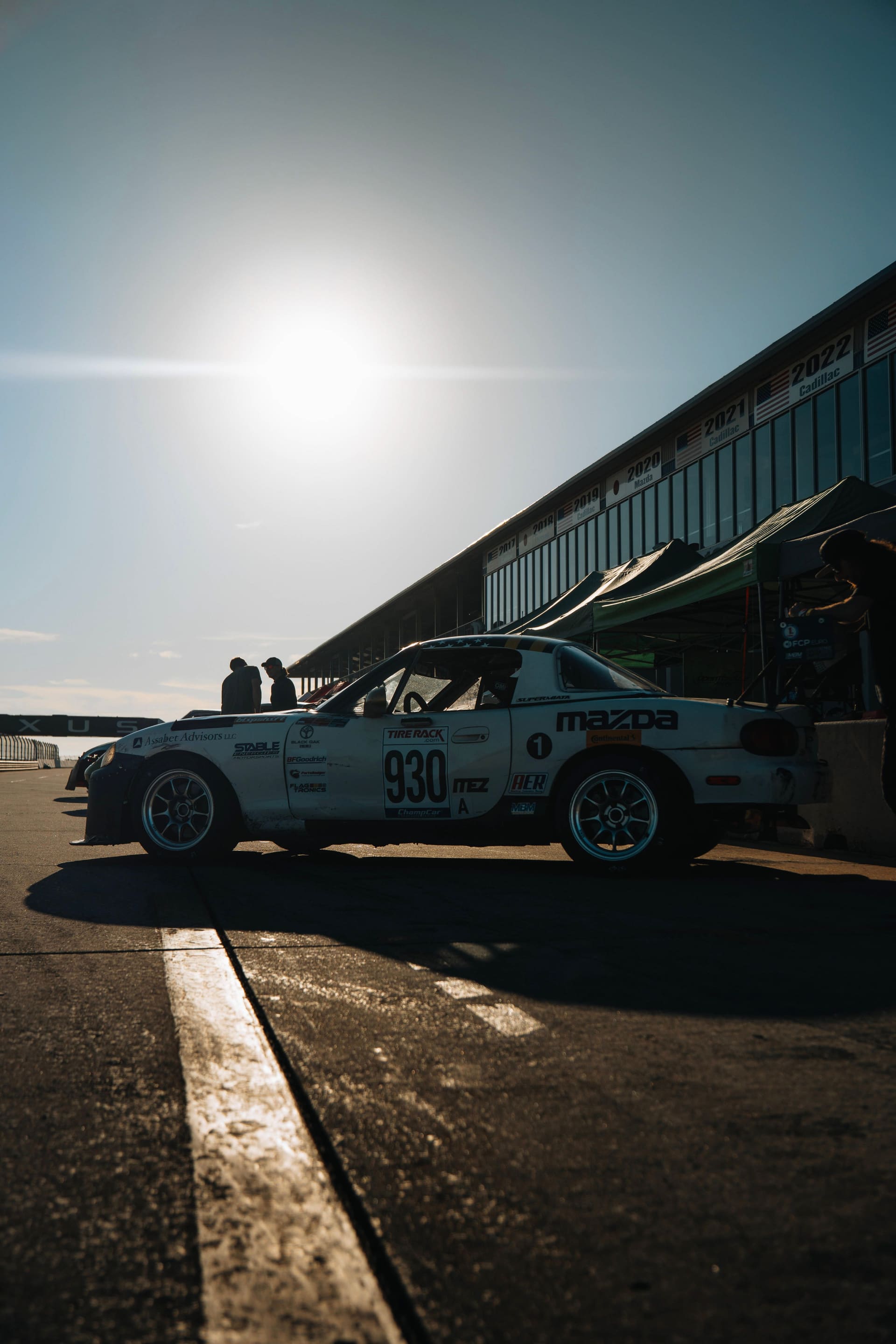The car silhouetted against low sun in the Sebring pits.