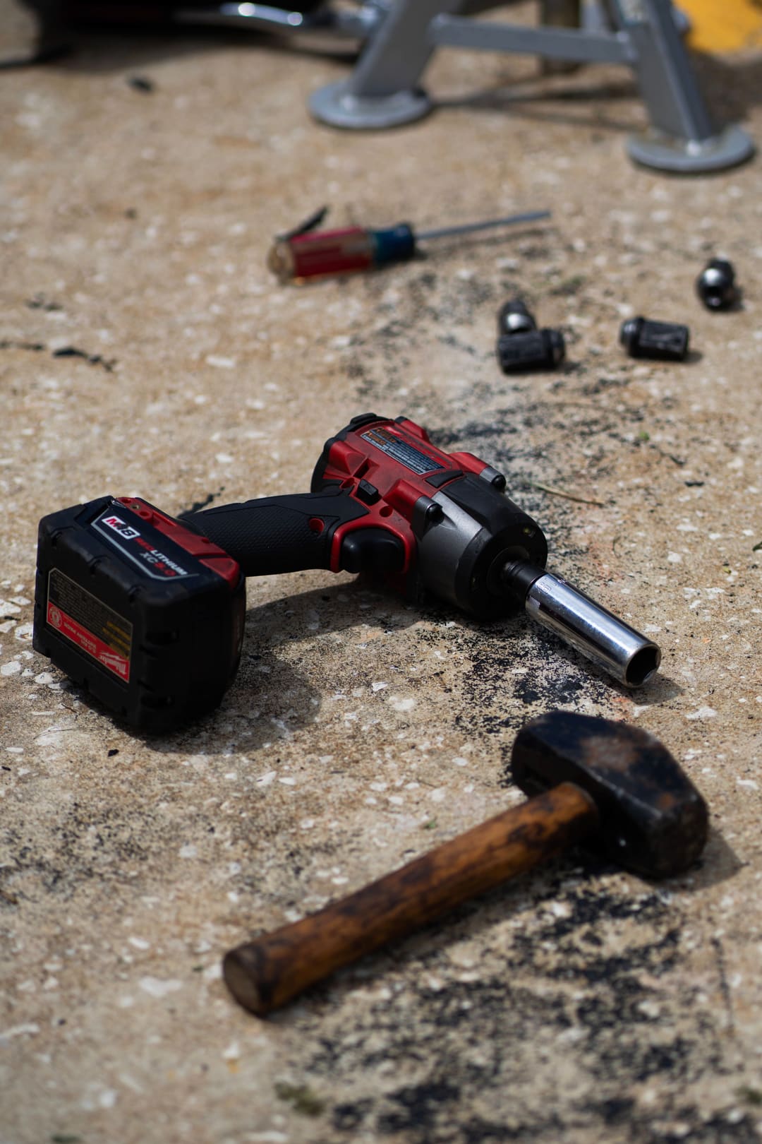 An impact gun and a hammer left on the paddock concrete.